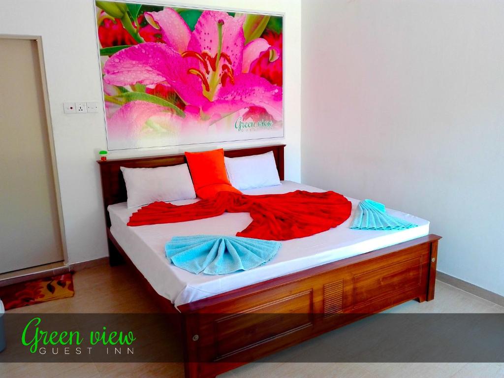 ナラタニヤにあるGreen View Guest Innの壁画が飾られた部屋のベッド1台