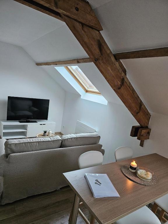 a living room with a couch and a table at L'appartement à la ferme in Béthune