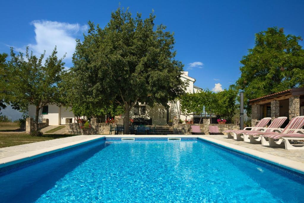 a swimming pool with chairs and a house at My Dalmatia - Villa Mandorla with private pool and Jacuzzi in Zadar