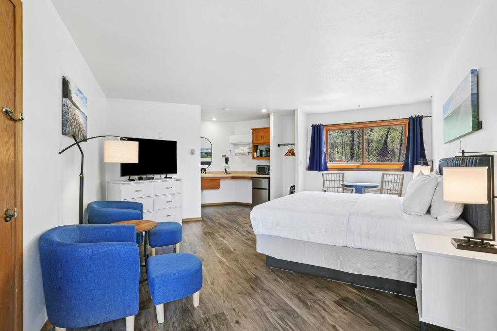 a bedroom with a large bed and blue chairs at Parkside Inn in Ellison Bay