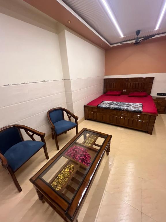a room with a bed and a table and chairs at Hotel ranjeet in Alīgarh