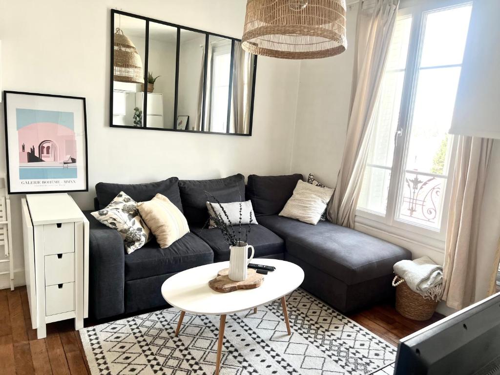 a living room with a blue couch and a table at Superbe appartement- 10 min Paris- Metro in Maisons-Alfort