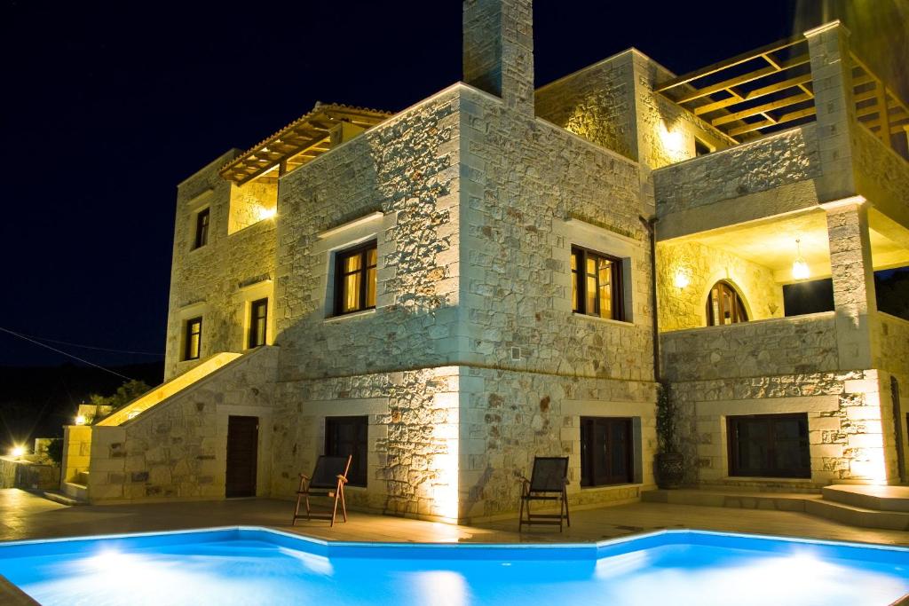 a villa with a swimming pool at night at Adam Villas in Falasarna