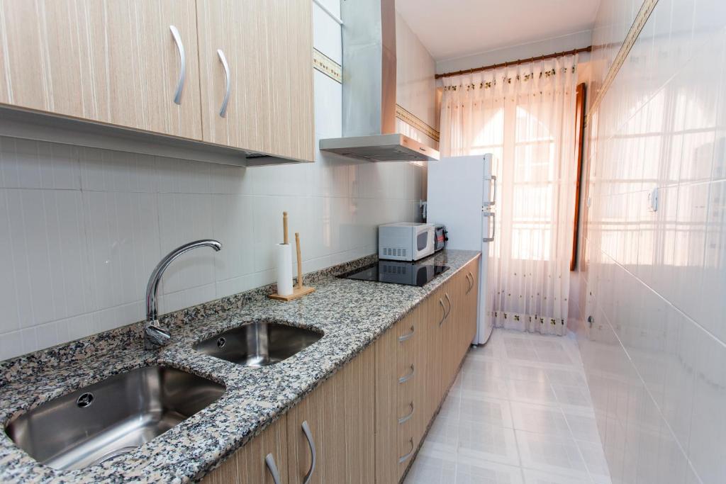 La cuisine est équipée d'un évier et d'un réfrigérateur. dans l'établissement Extrenatura Alojamiento Apartments, à Villafranca de los Barros