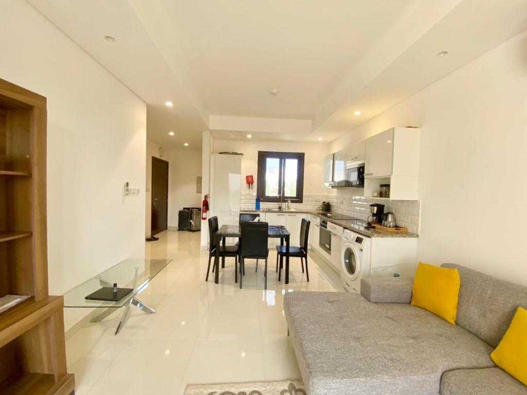 a living room and kitchen with a couch and a table at Bait Al Marina in Salalah