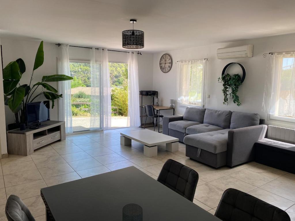 a living room with a couch and a tv at Le Cocon de Réals in Murviel
