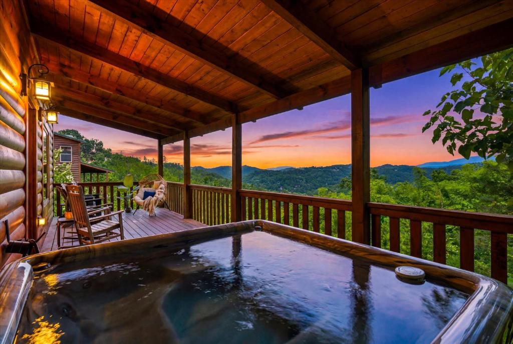a woman sitting on a deck in a hot tub on a porch at Heavenly Daze Amazing Mountain View, Hot Tub, Game Room! in Sevierville