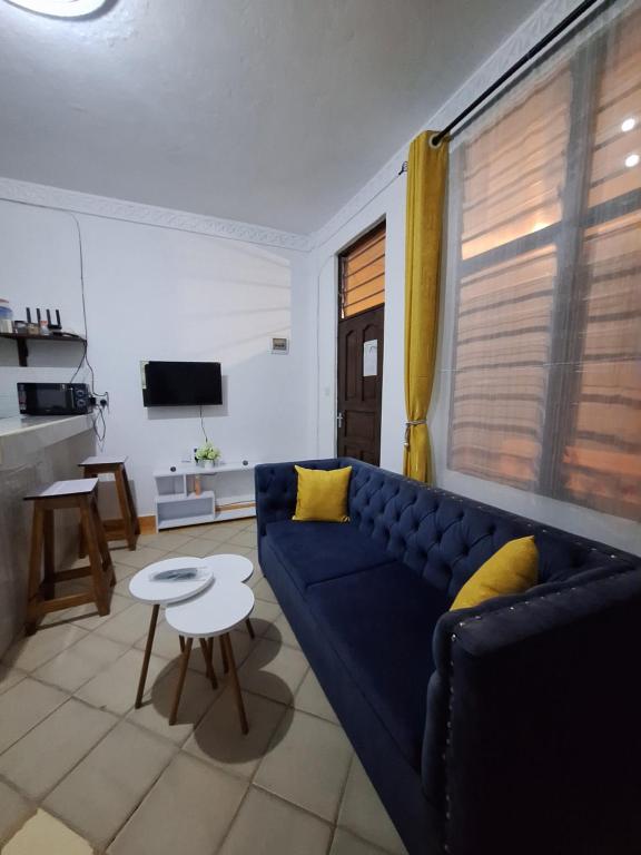 a living room with a blue couch and a table at holm's home studio in Diani Beach