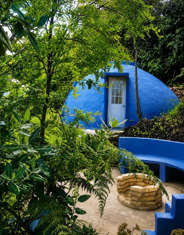 a blue house with a blue bench and trees at Hichata Breakfast Included in La Calera