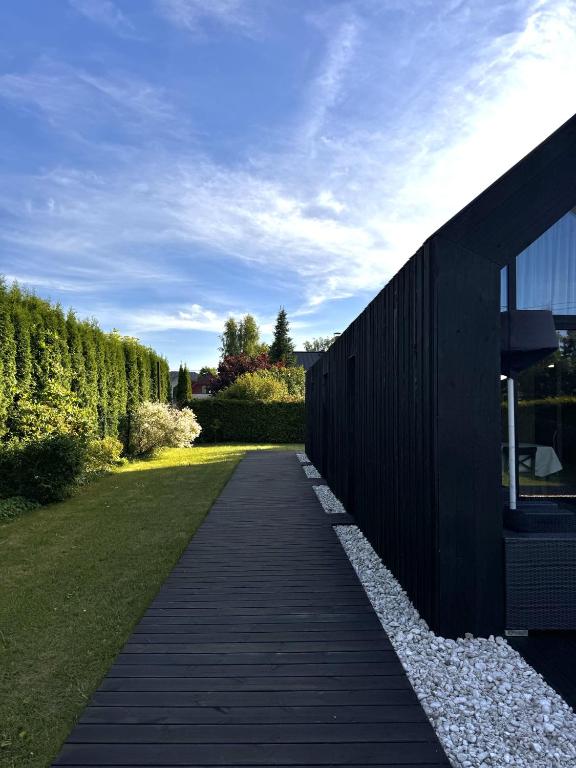 a wooden walkway next to a building with a yard at HARMONY Slow Living Stay in Bigauņciems