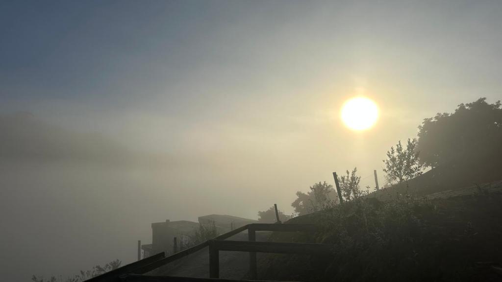 a misty sunrise with the sun in the background at Front in Domingos Martins