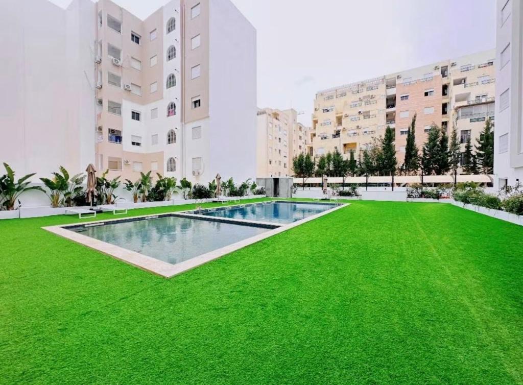 a large yard with green grass and buildings at rental per night in Nabeul