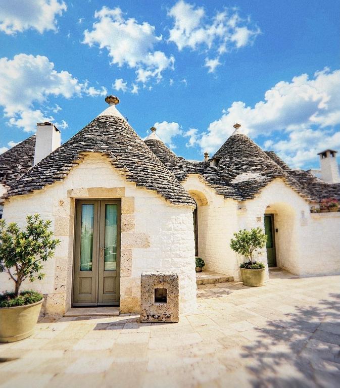 a white brick house with a roof at Trullo Galileo in Alberobello