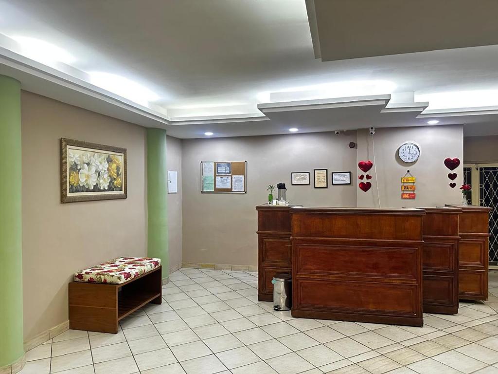 a waiting room with a bench and a desk in a hospital at Grande Hotel in Duque de Caxias