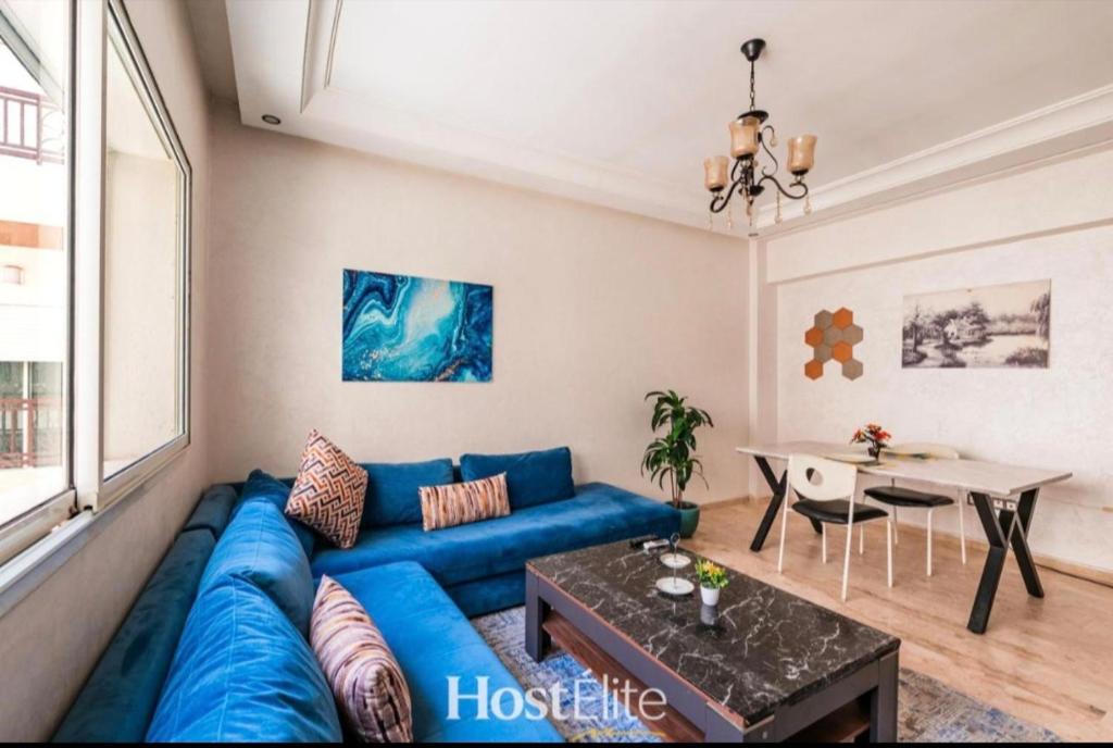 a living room with a blue couch and a table at Central Park in Mohammedia