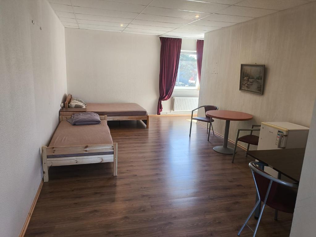 a room with two beds and a table and chairs at Vieta tavai atputai ar grilu in Liepāja