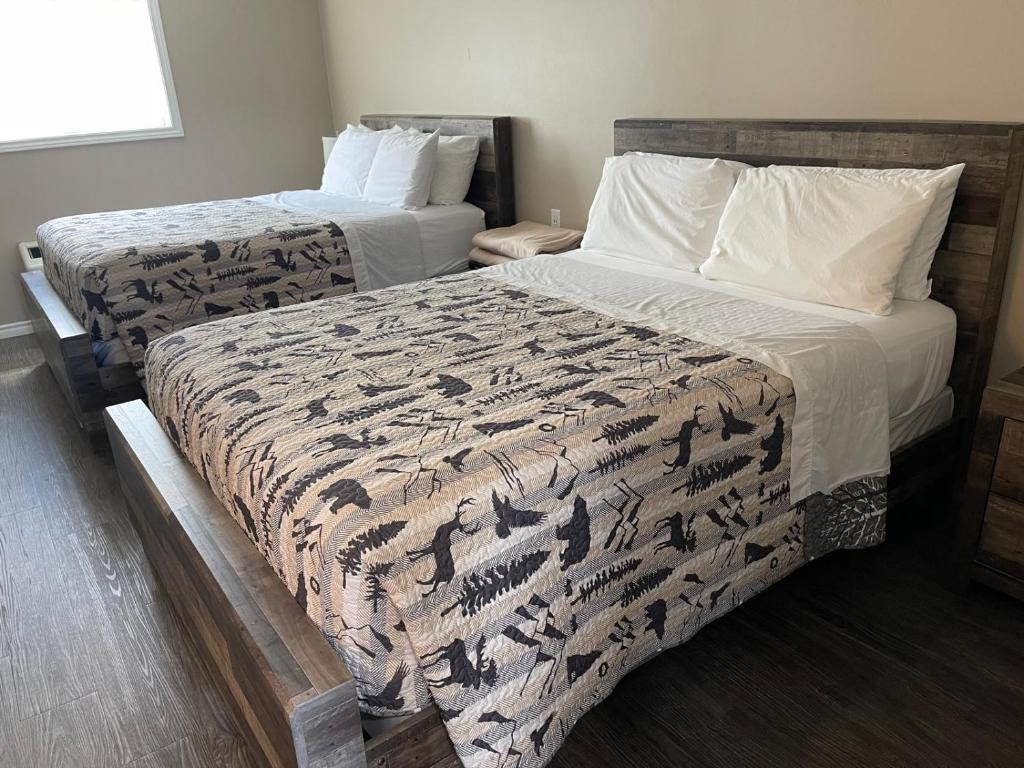 two beds in a hotel room with two beds at Timber Wolf Inn Motel in Nipigon