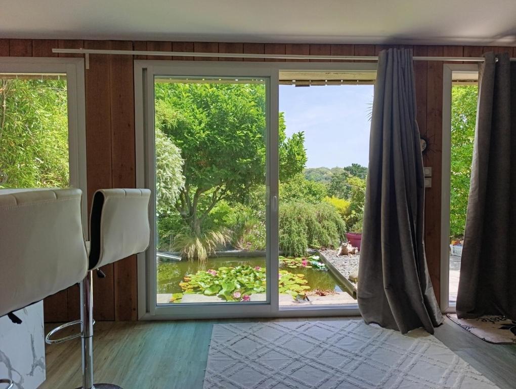 a room with a large window with a view of a pond at La suite mahradja in Quimper