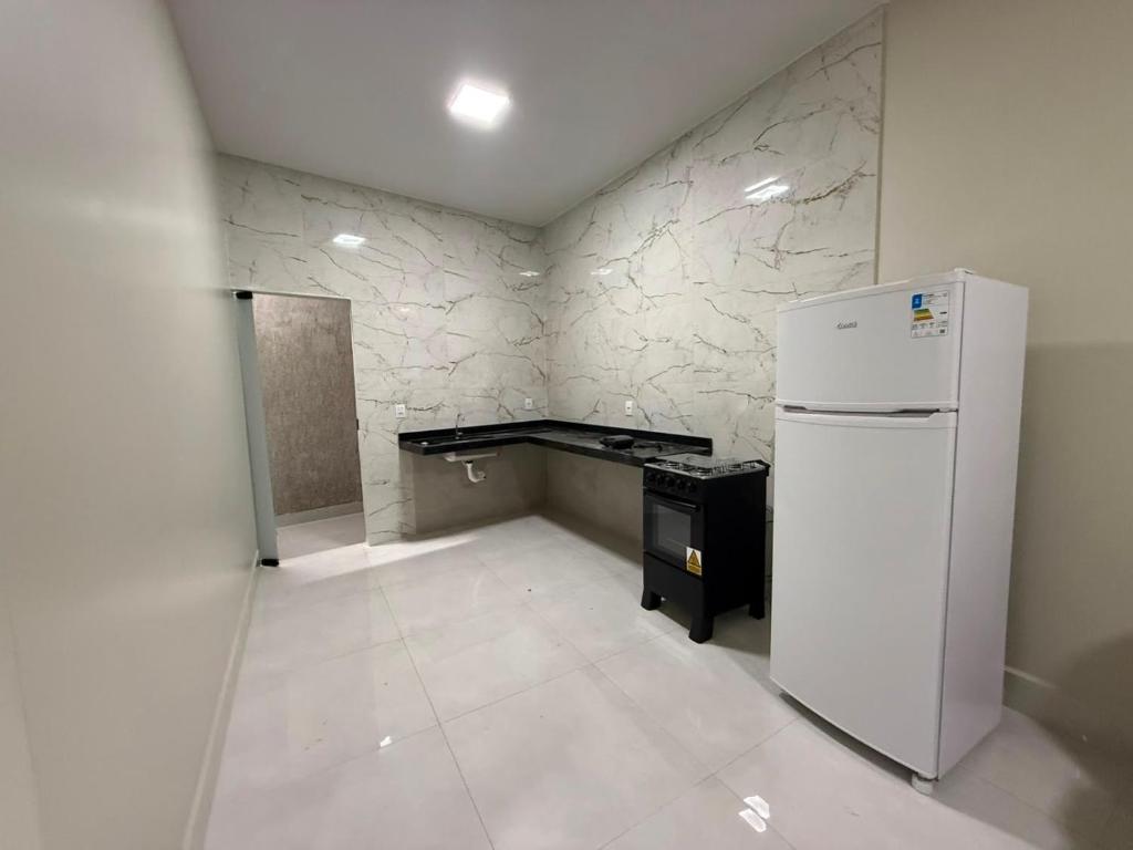 an empty room with a refrigerator and a desk at Casa Cor in Aruanã