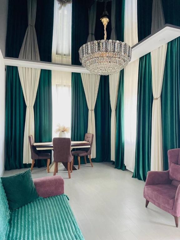 a living room with green curtains and a chandelier at Appartaments Anna Kostava in Kobuleti
