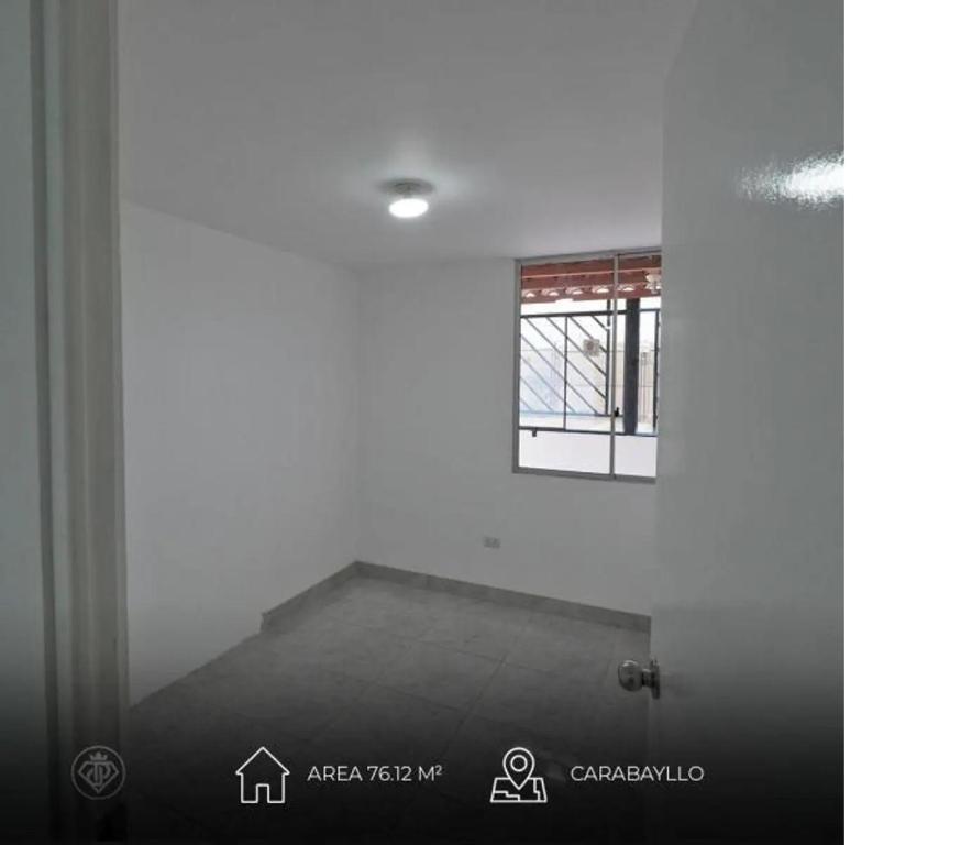a white room with a window and a staircase at Torre in Carabayllo
