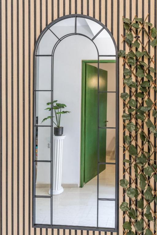 an arched mirror in a room with a green door at Varkiza Beach Summerhouse-Athens Riviera in Vari