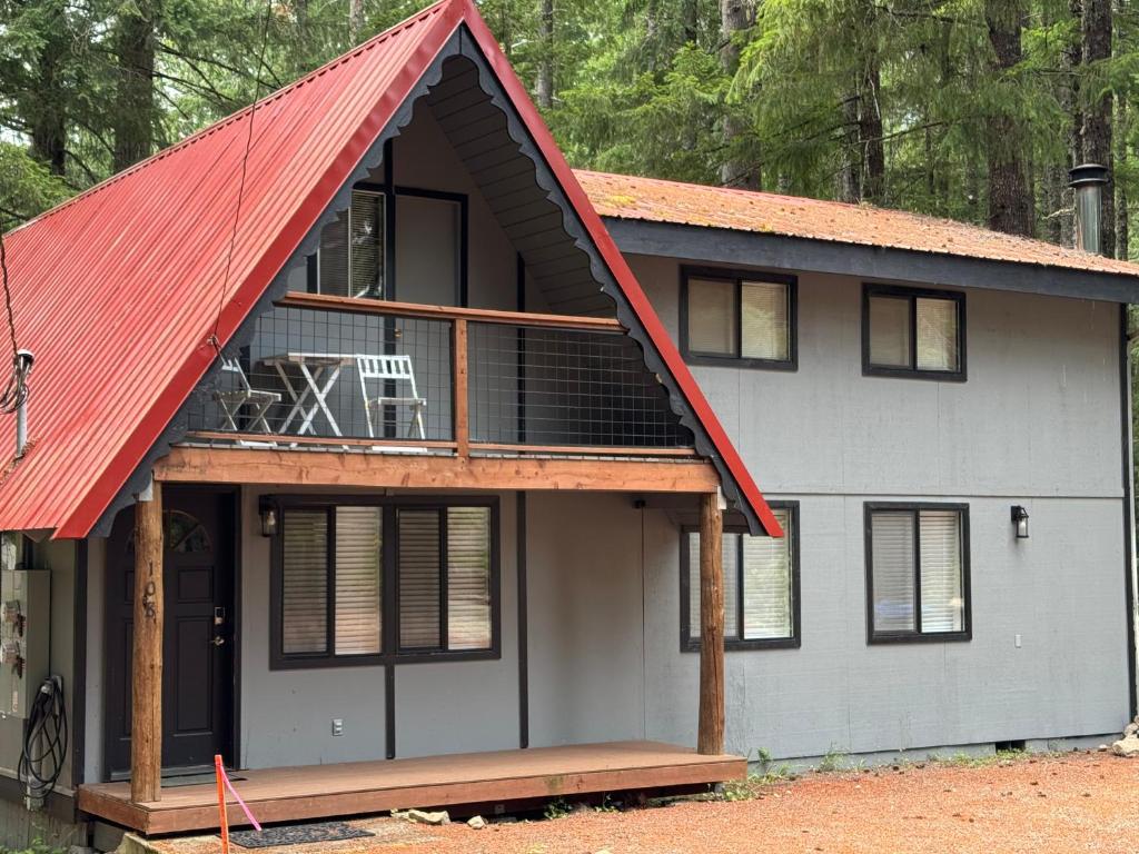 a house with a red roof with a deck at Tall Timber in Packwood