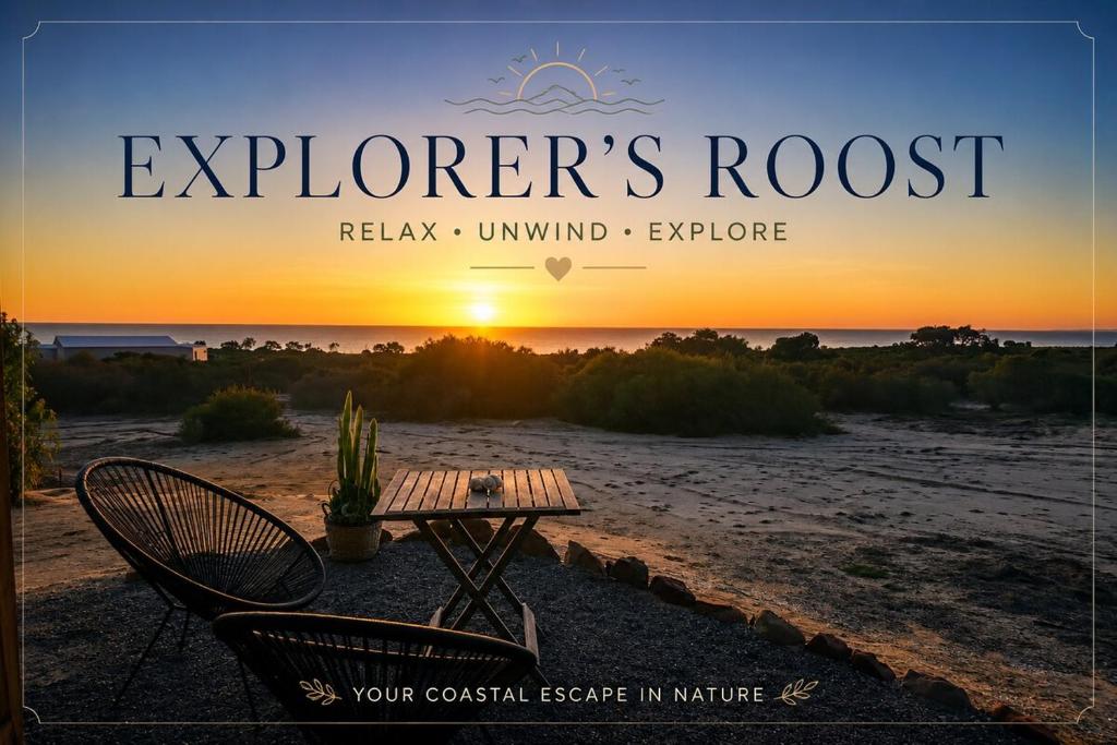 a table and chairs on a beach with the sunset at Explorers Roost in Kalbarri