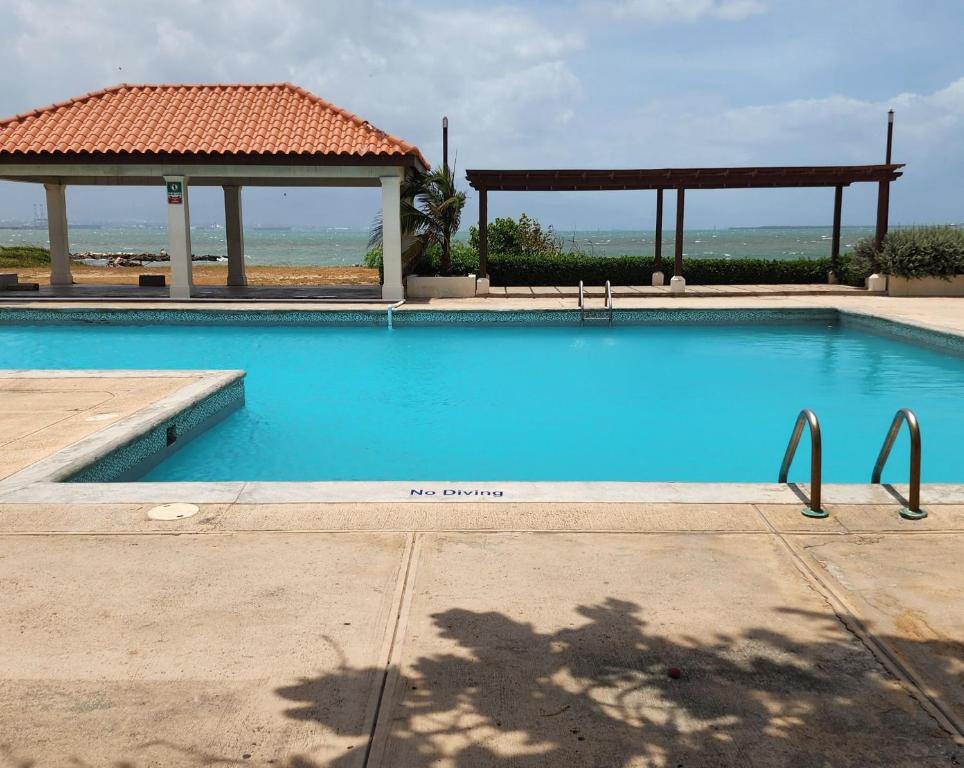 a large blue swimming pool with a gazebo at Beachfront Ocean View Loft with Beach, Pool and Parking in Portmore