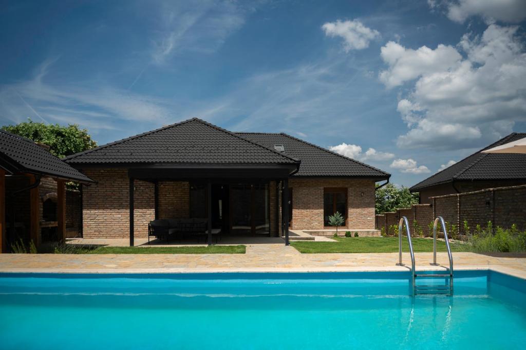 a brick house with a swimming pool in front of it at Villa Royalstone in Donja Ralja