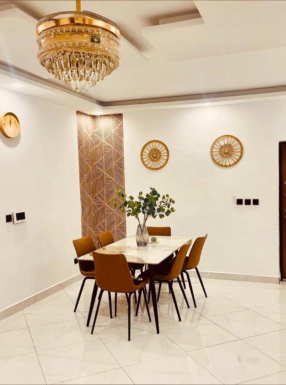 a dining room with a table and chairs and a chandelier at Appart lotus in Cocody