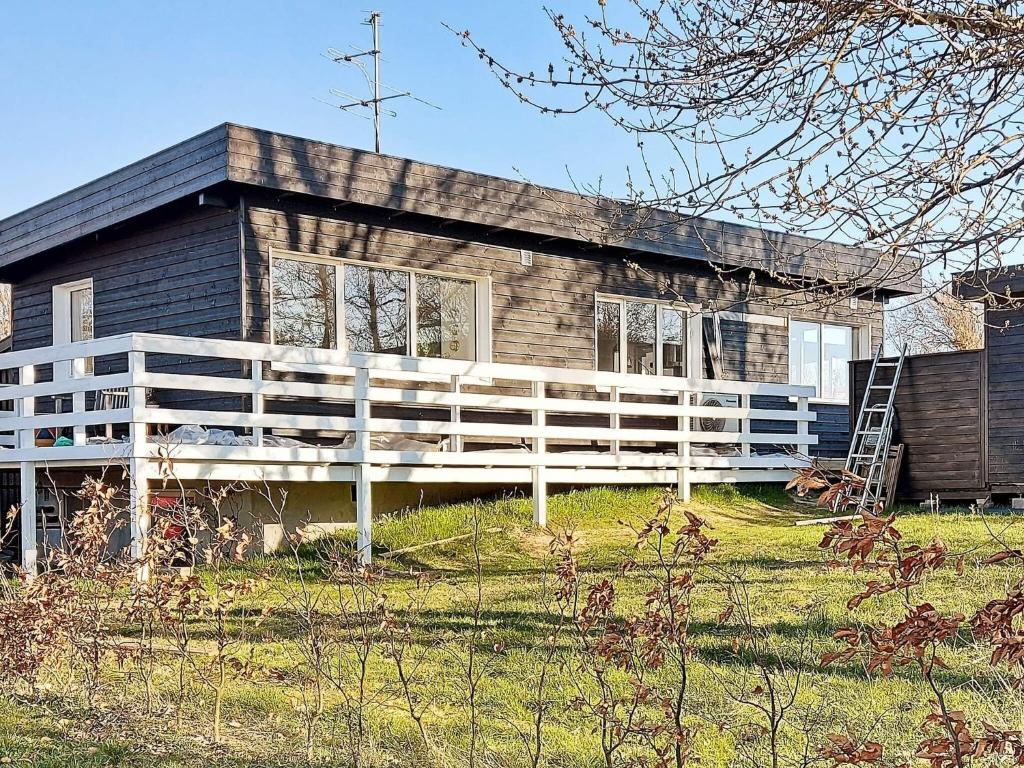 a house with a white fence in front of it at 6 person holiday home in Rude in Rude