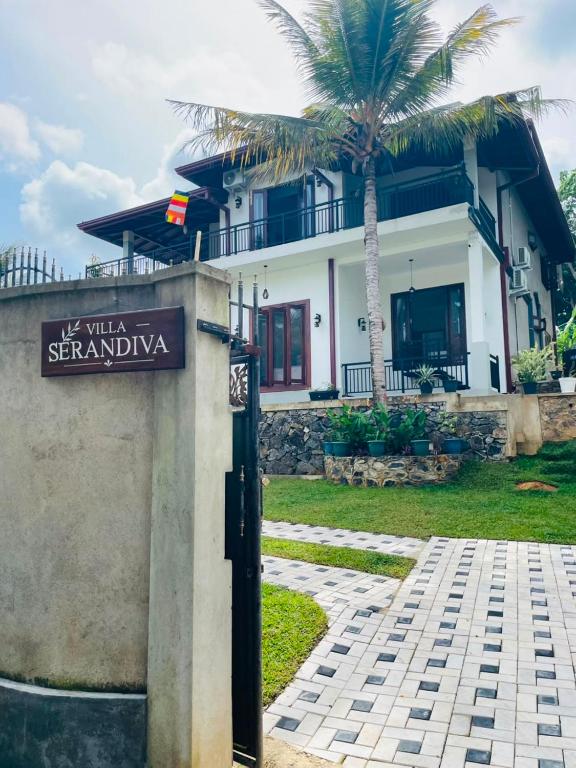 a sign in front of a house with a palm tree at Villa Serandiva in Galle