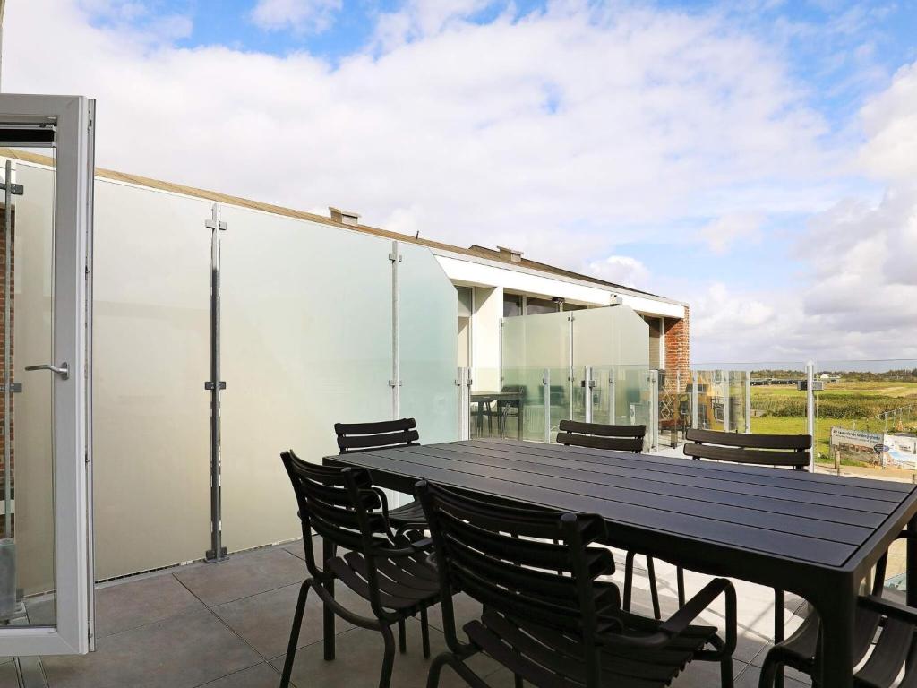 a black table and chairs on a patio with a view at 5 star holiday home in Ringkøbing in Ringkøbing