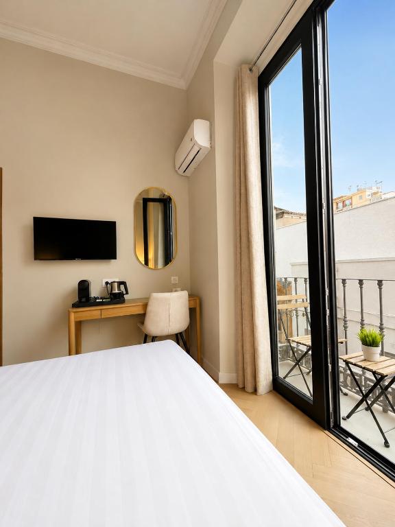 a bedroom with a bed and a sliding glass door at Malaga Rooms in Málaga