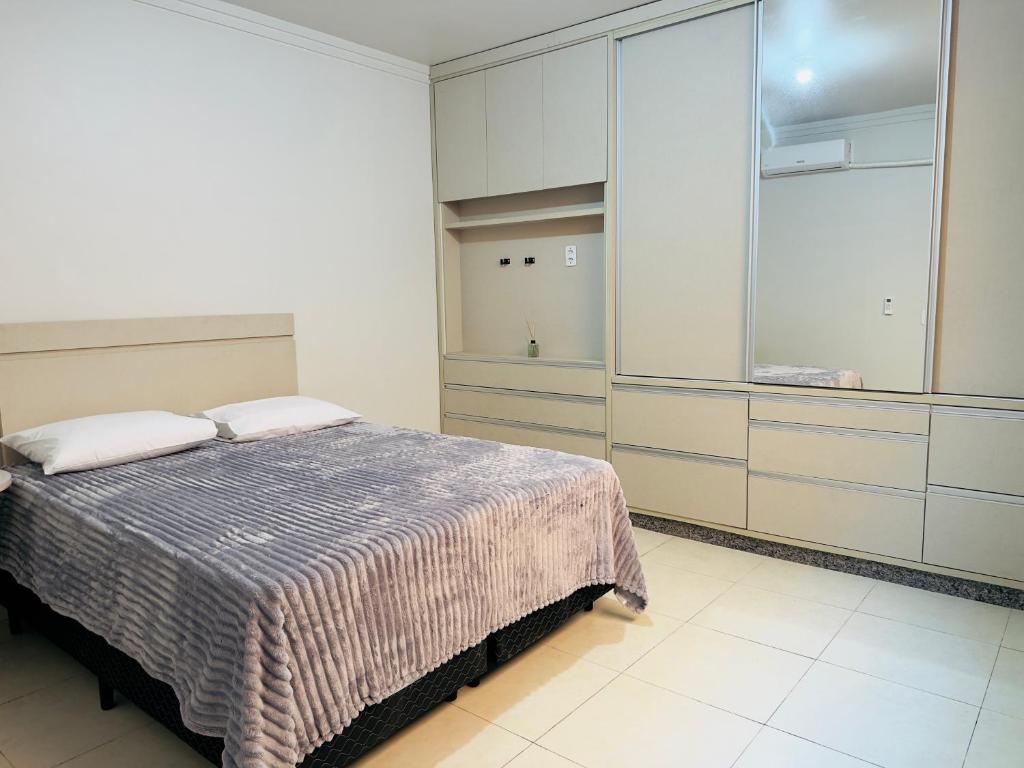 a bedroom with a bed and a large closet at Apartamento com 2 quartos, 2 banheiros e Garagem em sinop in Sinop