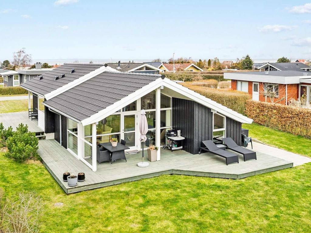 a large black and white house with a deck at 8 person holiday home in Bogense-By Traum in Bogense
