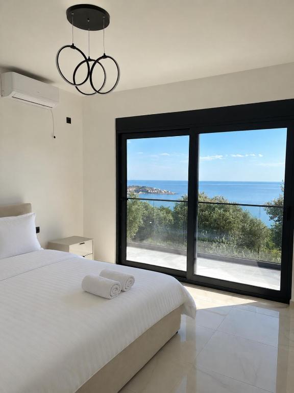 a bedroom with a bed and a large window at Villa Deromano in Šušanj