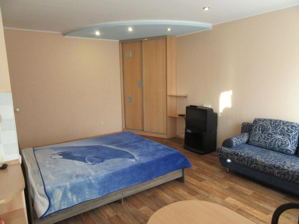 ペルミにあるApartments on Krasnovaのベッドルーム1室(ベッド1台、ソファ、椅子付)