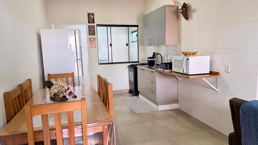 a small kitchen with a table and a refrigerator at Apartamento minutos do centro in Sinop