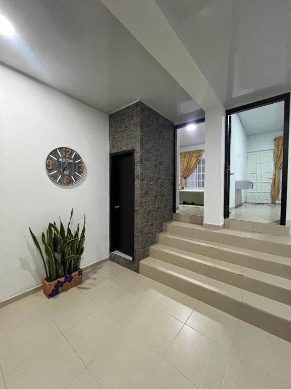 a room with stairs and a clock on the wall at Casa de Libre Independencia in Mocoa