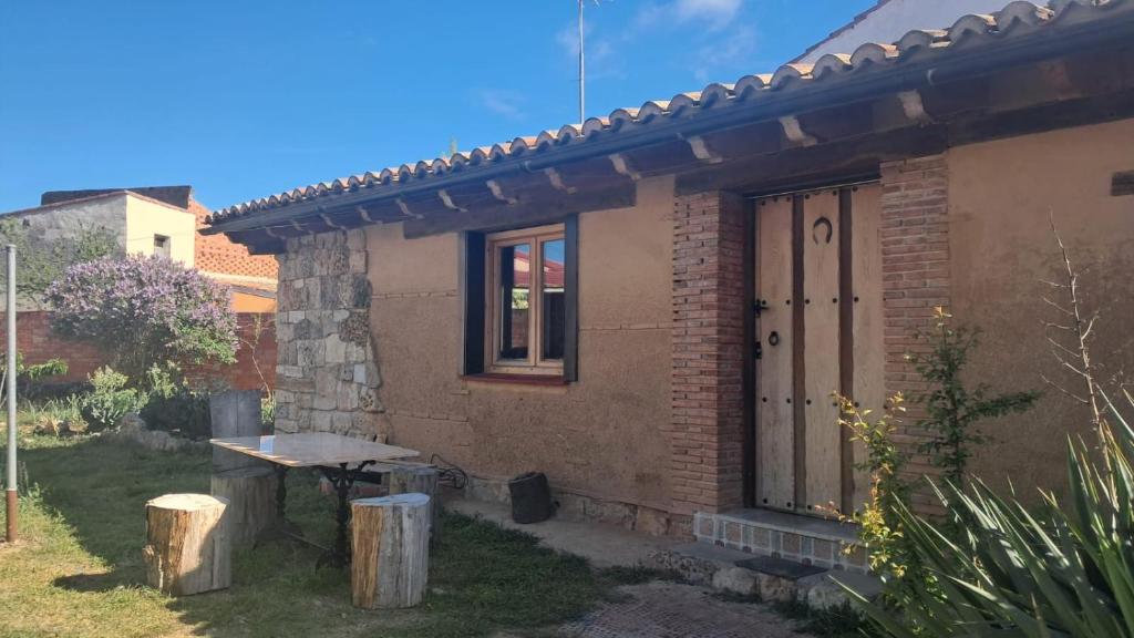 a small brick house with a picnic table in the yard at Casa eclipse in Padilla de Abajo