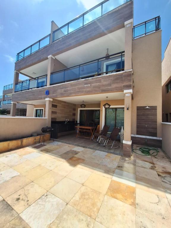 a house with a balcony and a patio at Apto Solluar Flecheiras Trairi in Trairi