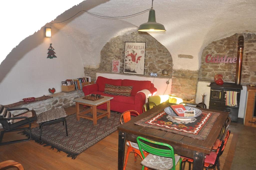 a living room with a red couch and a table at Casa Alex in Roure Turin