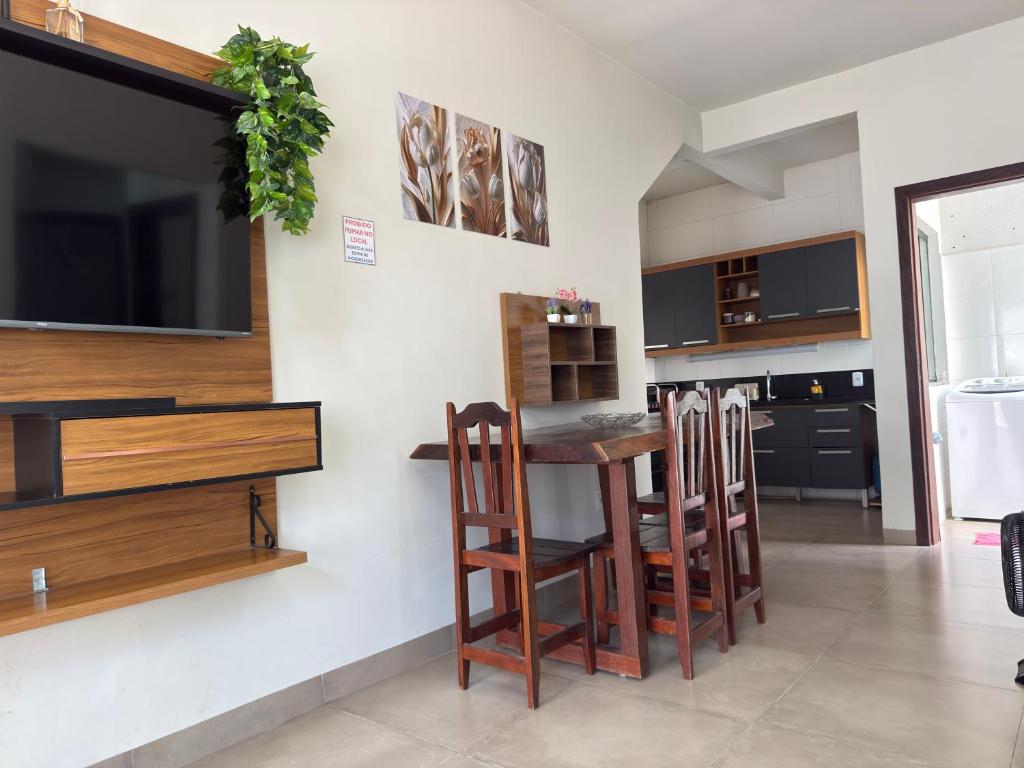 a kitchen with a table and chairs and a tv at Apartamento mobiliado com Wi-Fi in Sinop