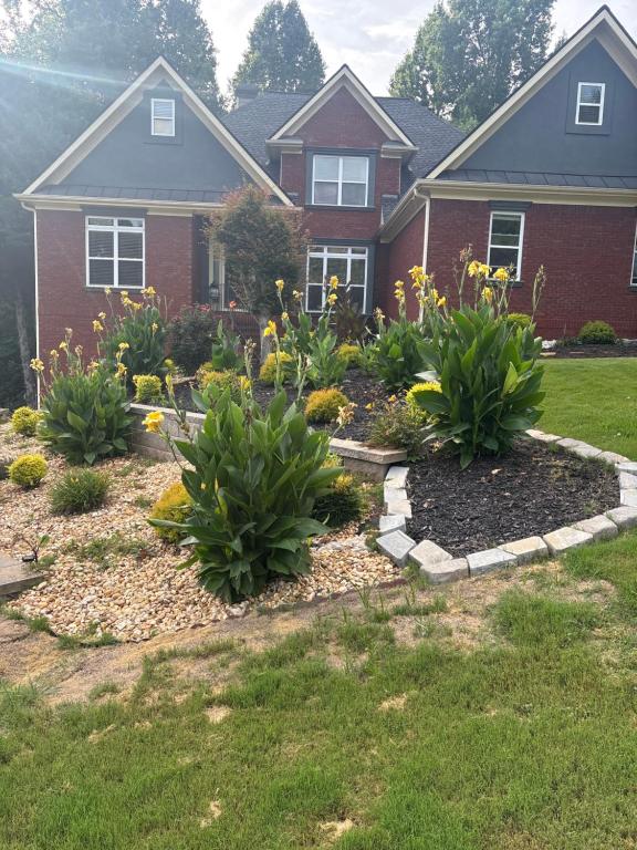 a garden in front of a house with flowers at The Abigail in Braselton
