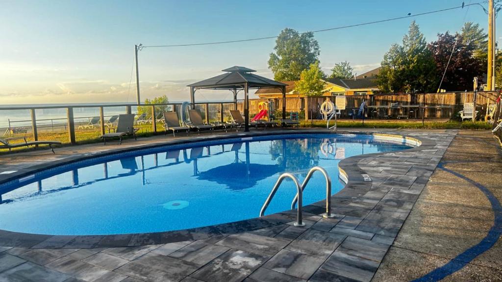 a large swimming pool with a gazebo next to the water at Beachy Daze in Wasaga Beach in Wasaga Beach