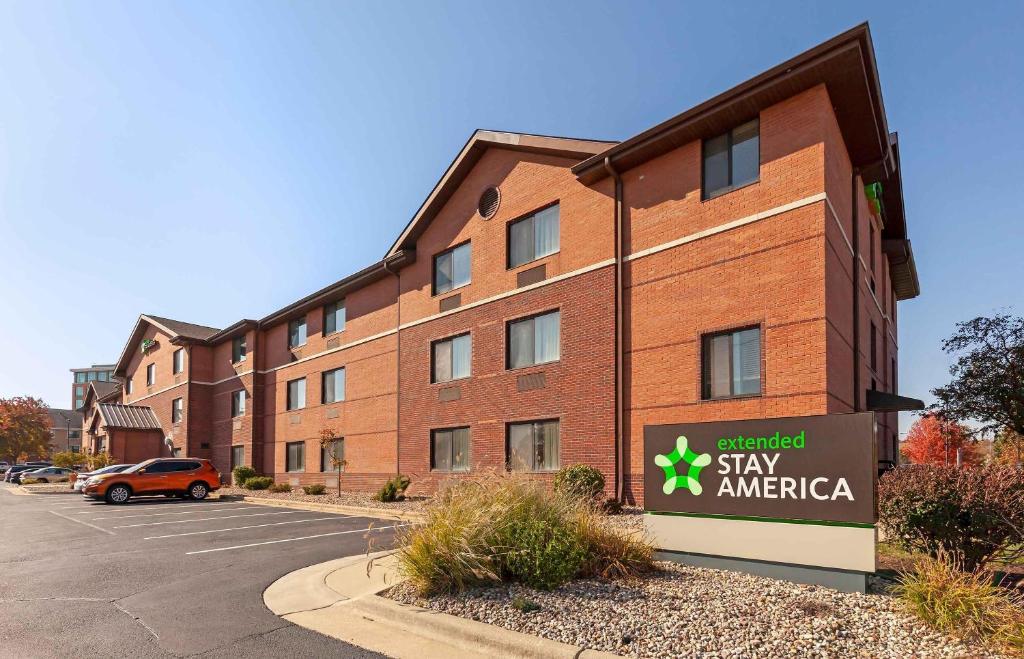 a building with a sign in front of a parking lot at Extended Stay America Select Suites - Madison - Old Sauk Rd in Madison