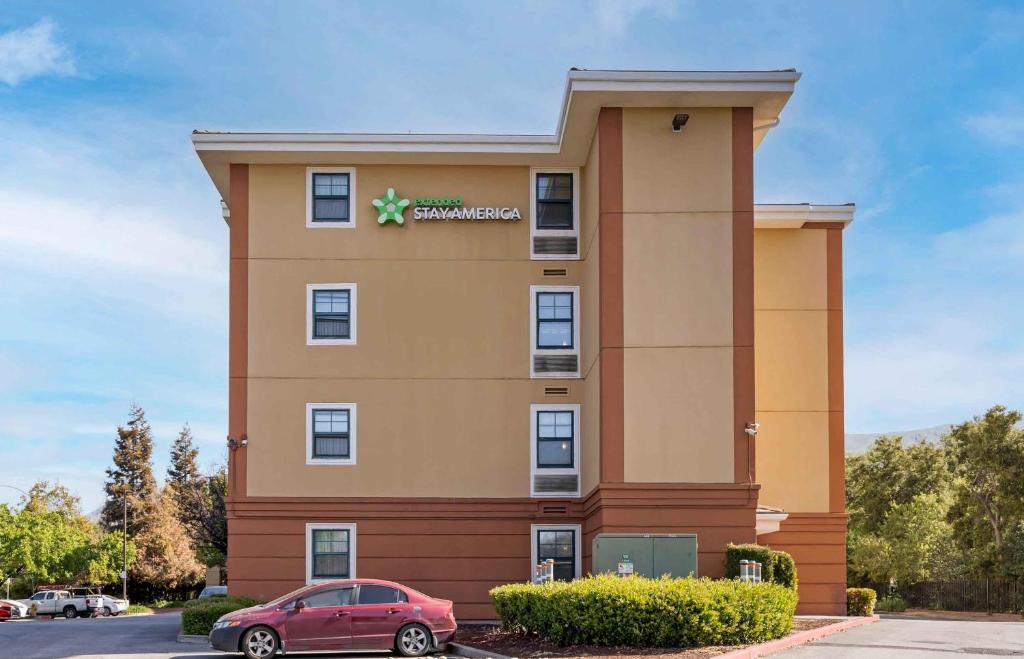 a hotel with a red car parked in front of it at Extended Stay America Suites - Fremont - Warm Springs in Warm Springs District