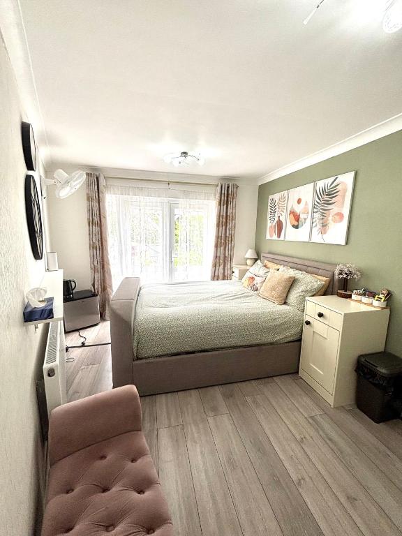 a bedroom with a bed and a chair in it at King room with garden access in Raynes Park
